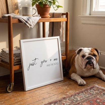 A quote print (White / White Frame) reading You Me and the Dogs, in a cosy mid-century living room in warm late-afternoon light, with Churchill nearby. [ks Background=White; Style=White Frame; kind=lifestyle]