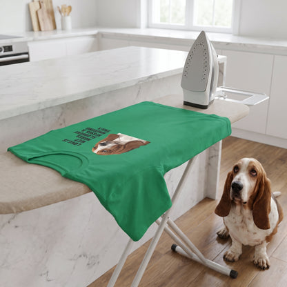 A custom pet t-shirt (Kelly) printed with "Love Is Wet Noses, Slobbery Kisses & Wagging Tails" and an illustration of Bertie the Basset Hound, in a minimalist white kitchen with a marble island, with Bertie nearby. [ks Colour=Kelly; kind=lifestyle]