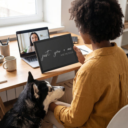 A Black woman in her 30s with natural curly hair in a mustard linen shirt with a quote print (Charcoal / Black Frame) reading You Me and the Dogs, with Koda beside them. [ks Background=Charcoal; Style=Black Frame; kind=lifestyle]