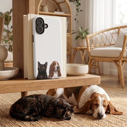 A custom pet tough iPhone case (Matte) featuring an illustration of Ember the tortoiseshell cat & Bertie the Basset Hound, in a boho living room with rattan, plants and a jute rug, with Ember & Bertie nearby. [ks Finish=Matte; kind=lifestyle]