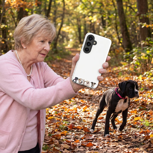 A white-haired grandmother in her 80s in a soft pink cardigan and pearls with a custom pet Galaxy phone case (Tough Matte) featuring an illustration of Domino the Boxer, Freckles the Great Dane, Arrow the Whippet, Sunny the Labrador Retriever & Jasper the Jack Russell Terrier, with Domino beside them. [ks Style=Tough Matte; kind=lifestyle]